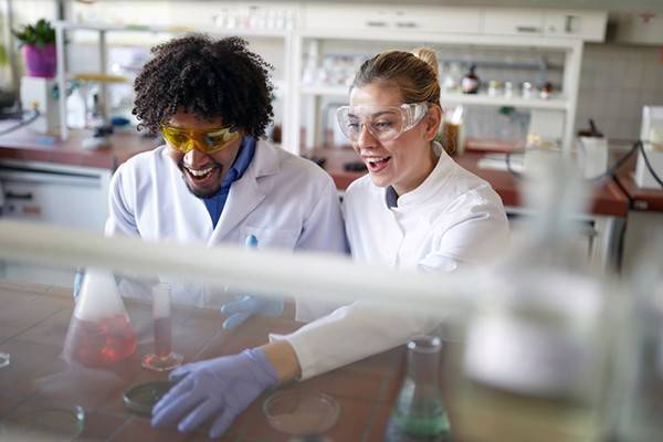 two excited male and female students in a lab