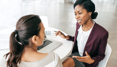 Two women seated at a table in a consulting meeting