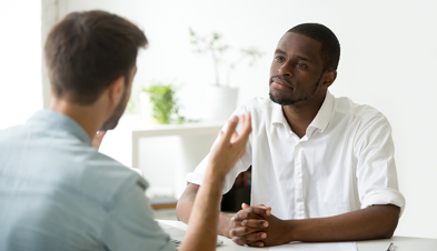 Two men seated at a desk in a job interview